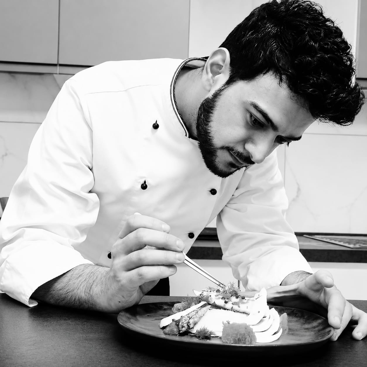 Lo Chef Salvatore Mammano mentre impiatta con le pinze